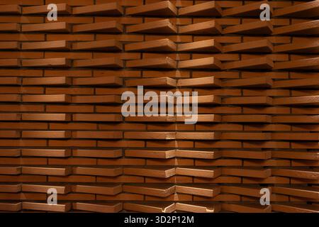 A modern brick wall with a dynamic, protruding pattern creates an interesting play of light and shadow, highlighting its unique architectural design. Stock Photo