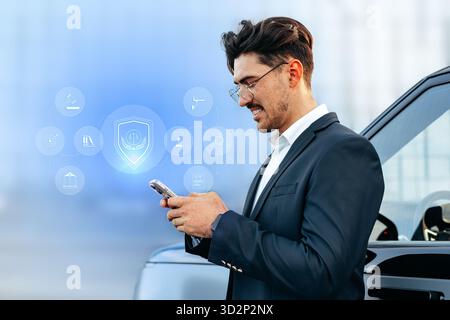Person using smartphone while standing next to a car in a modern setting Stock Photo
