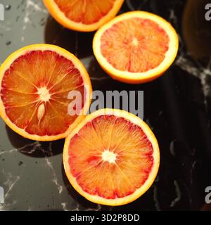 Fresh Sliced Blood Oranges on Black Marble Background Stock Photo