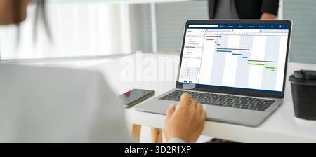 Project planning software for modish business project management on the computer screen showing timeline chart of the team project Stock Photo