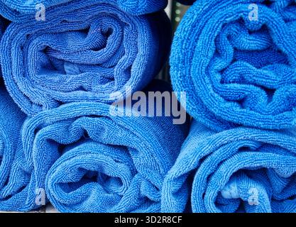 Neatly rolled up cozy blue spa towels. Stock Photo
