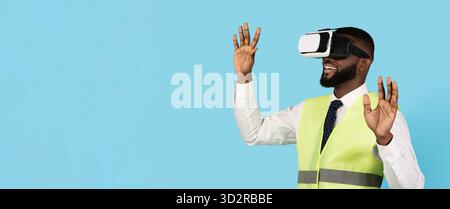 Amazed Black Male Construction Engineer Wearing VR Glasses Over Blue Background Stock Photo