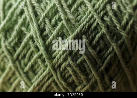 Cozy close up texture of green wool yarn. textile background showing an intricate pattern of fiber and thread, perfect for calm knitting or craft hobb Stock Photo