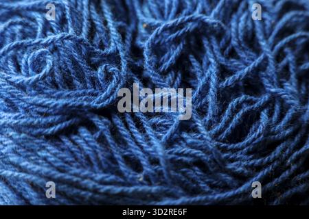Macro closeup view of tangled blue yarn creating textured background. wool fiber detail shows complexity of thread, ideal for crafting or knitting con Stock Photo