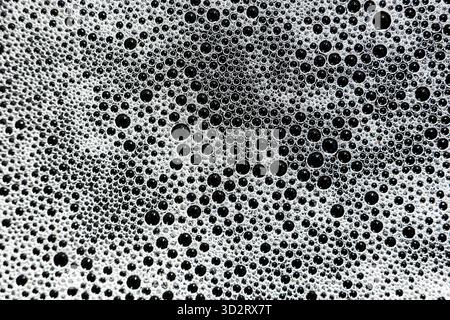 Refreshing abstract pattern showcasing clean foam bubbles and white suds on dark background. intricate texture of varied bubble sizes creates captivat Stock Photo