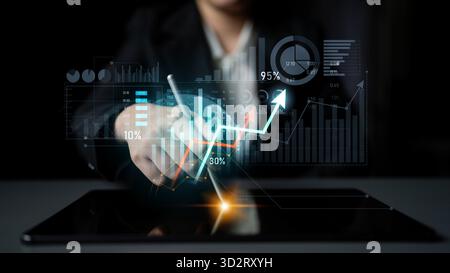 A business professional uses a digital tablet to analyze financial data, showcasing interactive graphs and charts that highlight growth trends and mar Stock Photo