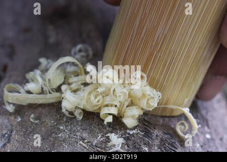 Detailed closeup of hand in woodworking craft, using tool for carving timber. focus on wood shaving shows satisfying process of traditional carpentry Stock Photo