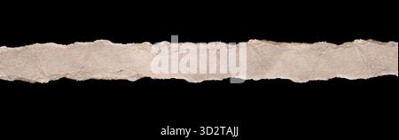 Isolated horizontal strip of torn light brown cardboard paper runs across the center of the image on a black background and clipping path. Stock Photo