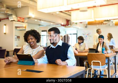Diverse business team collaborating on tablet in modern office Stock Photo