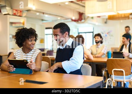 Colleagues collaborating on tablet in modern office Stock Photo
