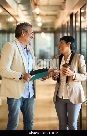 Business colleagues discussing project ideas in office hallway - legal, insurance and financial advisory Stock Photo