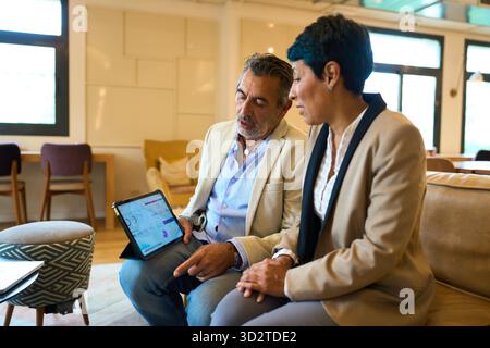 Business colleagues analyzing data on tablet together - legal, insurance and financial advisory Stock Photo