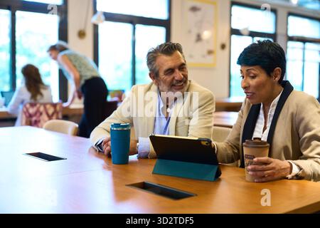 Business colleagues collaborating on tablet during office meeting Stock Photo