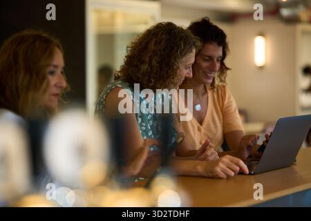 Women collaborating on laptop in modern office Stock Photo