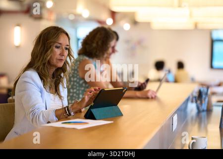 Businesswoman working on tablet in coworking office Stock Photo