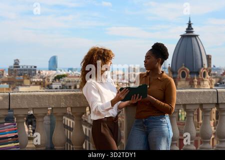 Colleagues collaborating on tablet on barcelona rooftop Stock Photo