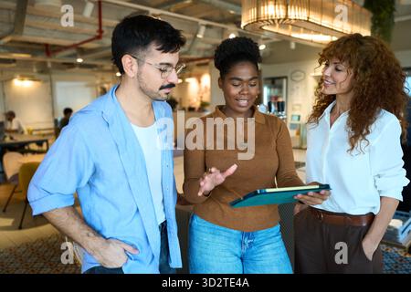 Diverse business team discussing project using tablet Stock Photo