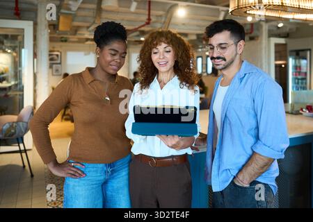 Diverse business team collaborating using digital tablet Stock Photo