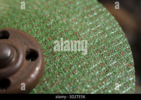 Rough macro close up of green abrasive wheel for grinding. industrial cutting disc shows gritty texture and powerful detail for metalwork workshop bac Stock Photo
