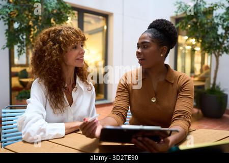 Businesswomen discussing during casual meeting at office Stock Photo