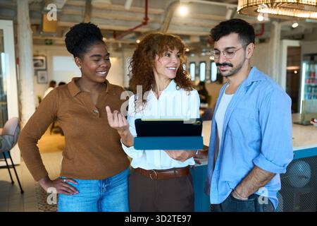 Diverse business team collaborating using digital tablet Stock Photo
