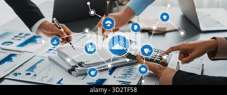 This image captures a collaborative business management scene with hands working on financial reports, charts, and technology tools, illustrating team Stock Photo