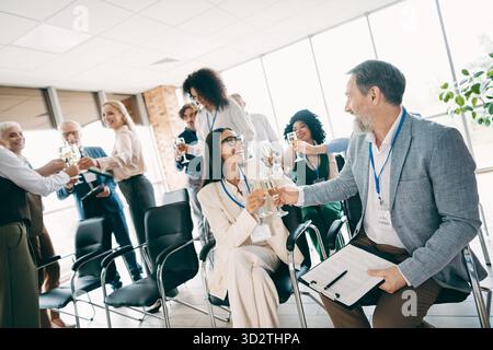 Diverse team celebrates success during a business event gathering in bright office with collaborative and positive energy Stock Photo