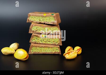 Gourmet pistachio chocolate bars stacked with scattered nuts. Perfect visual for dessert branding and product promotions.  Stock Photo
