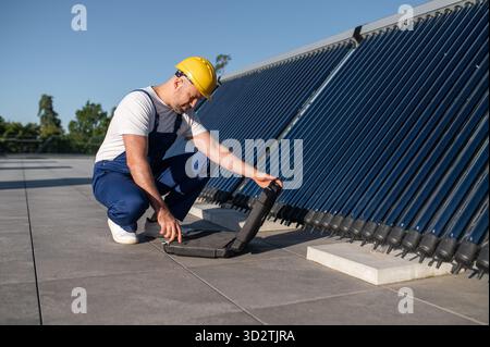 Technician using tool case examining solar power equipment Stock Photo