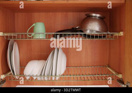 Tidy wooden cabinet holding various kitchen items, Efficient and aesthetically pleasing home cooking area with wellarranged utensils Stock Photo