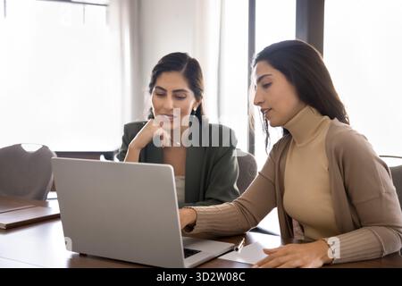 Two Latina businesswomen working together on laptop Stock Photo