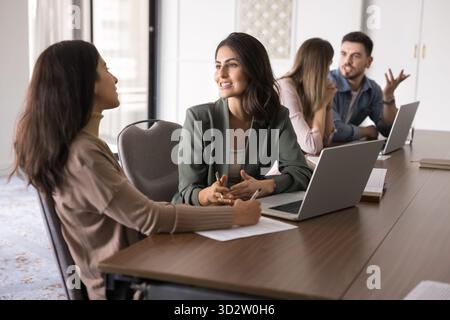 Two female colleagues engaged in positive and friendly conversation Stock Photo