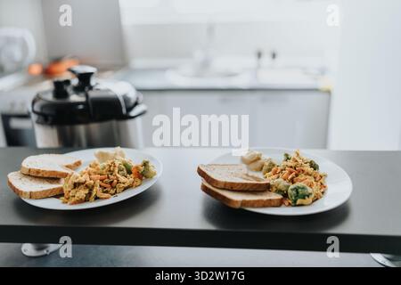 Two plates of vegetarian meals served with bread in a cozy kitchen Stock Photo