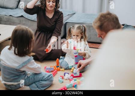 Family spending quality time together playing with toys on the living room floor Stock Photo