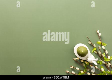 Festive Easter decorations include a cute bunny figurine, colorful egg, and delicate spring branches, creating a cheerful atmosphere perfect for the h Stock Photo