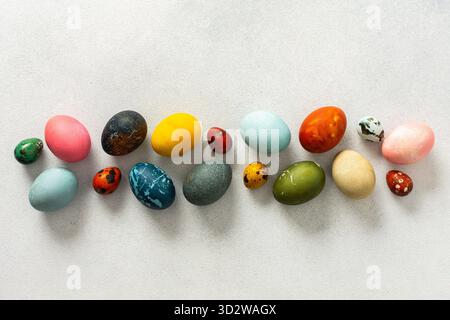 Various Easter eggs in vibrant colors and patterns are neatly arranged, showcasing the joy and creativity associated with spring celebrations and fami Stock Photo
