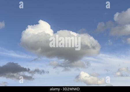 White Cumulus mediocris cloud against blue sky, lower left gray Cumulus fractus, international Stock Photo