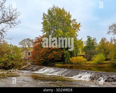 Stone houses and weir on the River Wharfe at Grassington, North Yorkshire, in autumn. Stock Photo