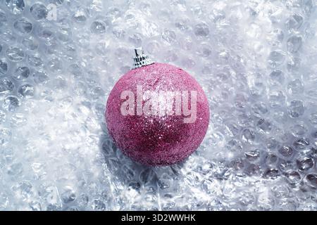 Glittery pink Christmas bauble on bubble wrap Stock Photo