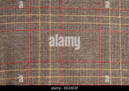 Close-up of a textured fabric with a plaid pattern in brown, red, and yellow. Great for backgrounds and textures Stock Photo