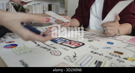 Designers analyzing user experience concepts and interface designs, highlighting teamwork and innovation in a collaborative setting Stock Photo