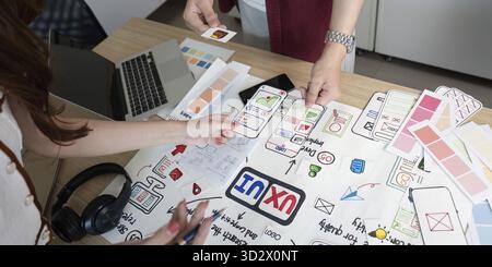 Designers engaged in a hands-on UX and UI design process, showcasing collaboration and creativity in a modern workspace Stock Photo