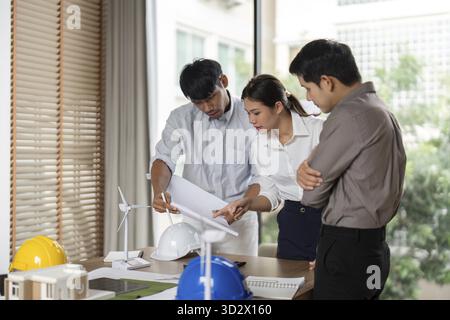 A team collaborates on architectural project planning, emphasizing sustainable practices and innovative designs in the workspace Stock Photo