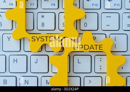 Two interlocking gear with text SYSTEM UPDATE on a computer keyboard. Improvement, maintenance, or software upgrade concept. Stock Photo
