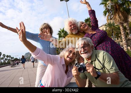 Happy senior friends traveling and taking self portrait outdoors Stock Photo