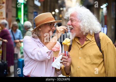 Senior couple sharing ice cream during city vacation Stock Photo