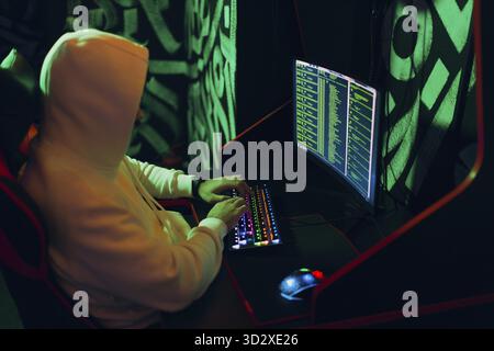 Hacker using computer malware software and hacking binary code green digital interface Stock Photo