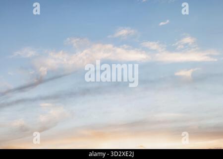 Background of evening sky, light stretched clouds in the sun. Sky with a gradient of color from warm to cold Stock Photo