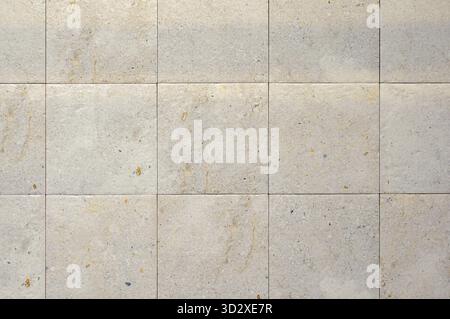 Square ceramic tile in light beige color, matt. Wall tile texture, stone imitation, noisy structure Stock Photo