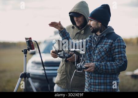 Man pilot controlling quadcopter drone with remote controller pad Stock Photo